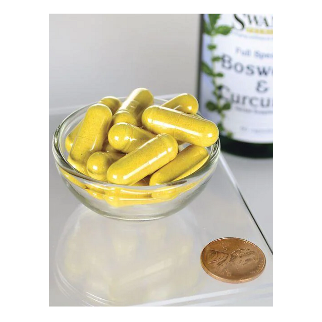 A small glass bowl filled with yellow capsules is next to a penny, beside a Swanson bottle labeled "Boswellia and Curcumin 60 Capsules," emphasizing joint health benefits.