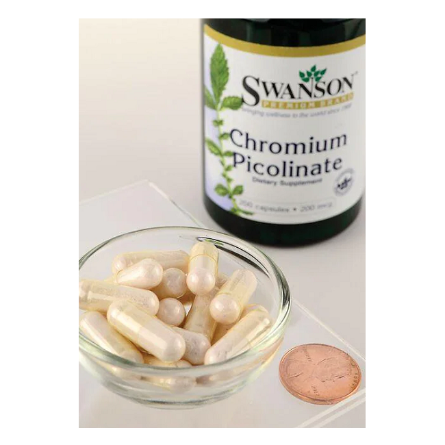 A Swanson Chromium Picolinate 200 mcg 100 Capsules bottle, promoting heart health, stands in the background. In the foreground, a small glass bowl of capsules is placed beside a penny.