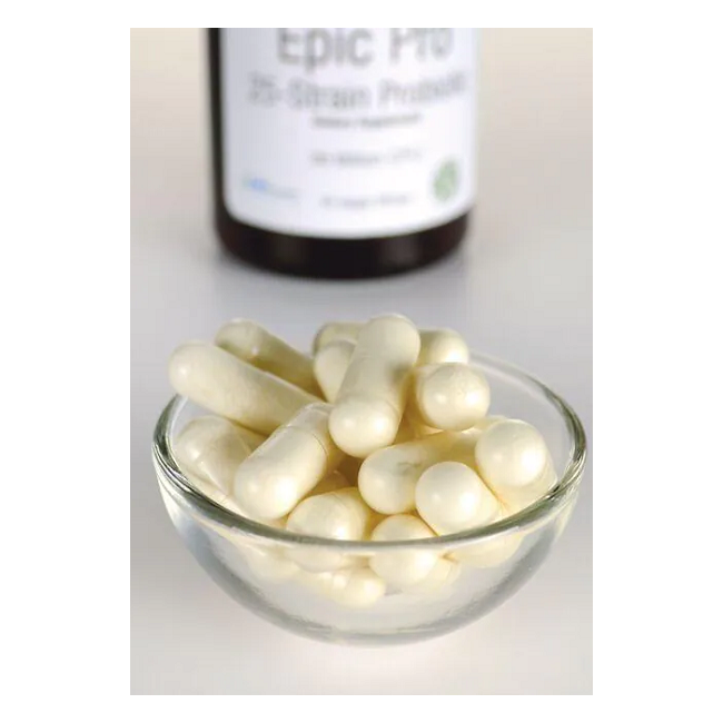 In the foreground, a glass bowl holds white capsules, implying they are Swanson's Epic Pro 25-Strain Probiotic in veggie embo capsules, with a blurred bottle seen in the background.