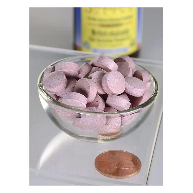 Swanson Vitamin B-12 - 2500 mcg Methylcobalamin tablets, in a glass bowl next to a penny for size comparison, enhance energy production. A blurred bottle is visible in the background.