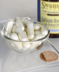 Thumbnail for A bowl of white capsules is placed next to a penny, with a bottle labeled 