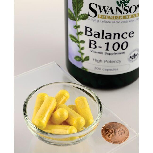 A bottle of Swanson Vitamin B-100 Complex - 300 capsules, promoting cardiovascular health and immune health, with a coin next to it.