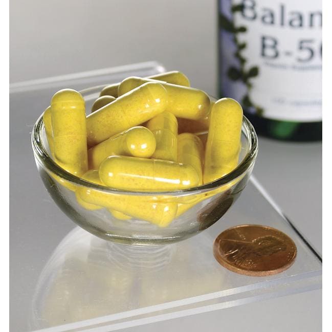 Vitamin B-50 Complex - 100 capsules in a bowl next to a bottle, promoting nervous system and cardiovascular health. (Swanson)