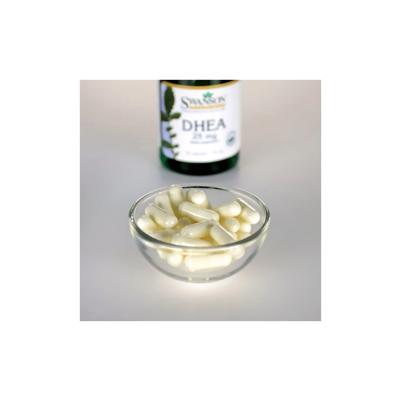 A bottle of Swanson DHEA 25 mg 30 Capsules supplement for hormonal balance with a bowl of capsules in the foreground.