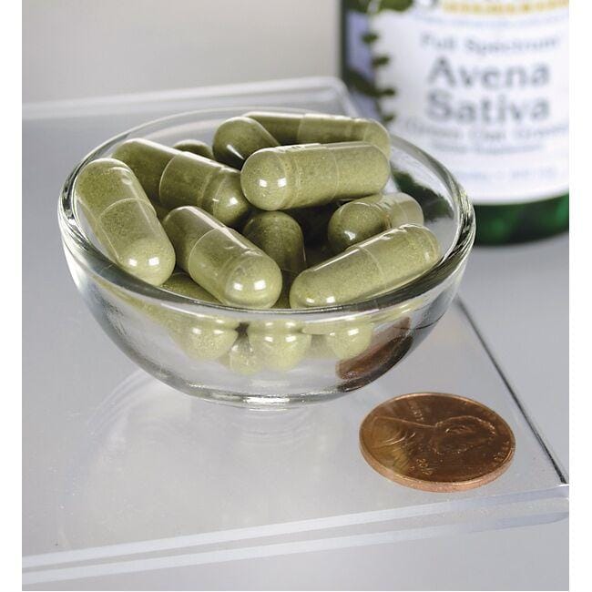 Un bol de Swanson Avena Sativa - 400 mg 60 gélules à côté d'une bouteille d'huile d'olive.