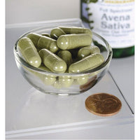 Vignette pour Un bol de Swanson Avena Sativa - 400 mg 60 gélules à côté d'une bouteille d'huile d'olive.