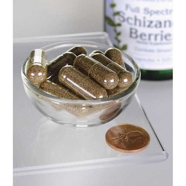SwansonLes baies de Schizandra - 525 mg 90 gélules, un tonique hépatique et un adaptogène, sont présentées dans un bol à côté d'un penny.