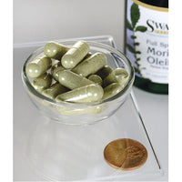 Vignette de Swanson's Moringa Oleifera - 400 mg 60 gélules dans un bol à côté d'une bouteille de Swanson's Moringa Oleifera, mettant en évidence les avantages de la réduction du stress oxydatif et des dommages cellulaires.
