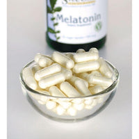 Vignette pour Swanson Melatonin - 0,5 mg 60 gélules végétales dans un bol en verre à côté d'une bouteille.