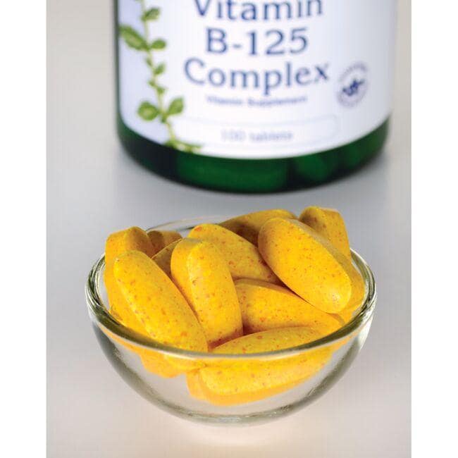 A bowl of yellow Swanson Vitamin B-125 Complex - 100 Tablets with a bottle in the background, promoting a healthy nervous system and cardiovascular health.