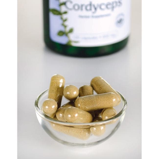 Swanson Cordyceps - 600 mg 120 gélules dans un bol à côté d'une bouteille de Swanson Cordyceps.