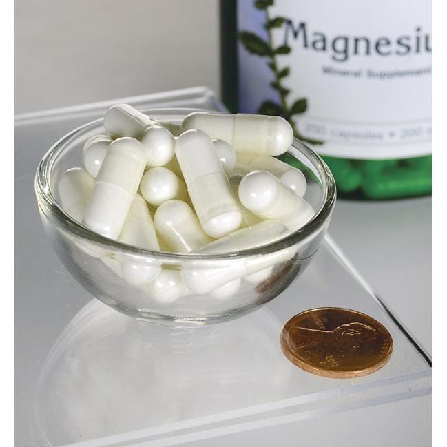 Un bol de pilules blanches à côté d'un flacon de Swanson Oxyde de magnésium - 200 mg 250 gélules.