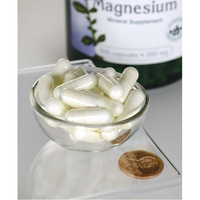 Swanson Oxyde de magnésium - 200 mg 500 gélules dans un bol à côté d'une bouteille.