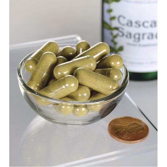 Swanson Cascara Sagrada - 450 mg 100 gélules dans un bol au dessus d'une bouteille.