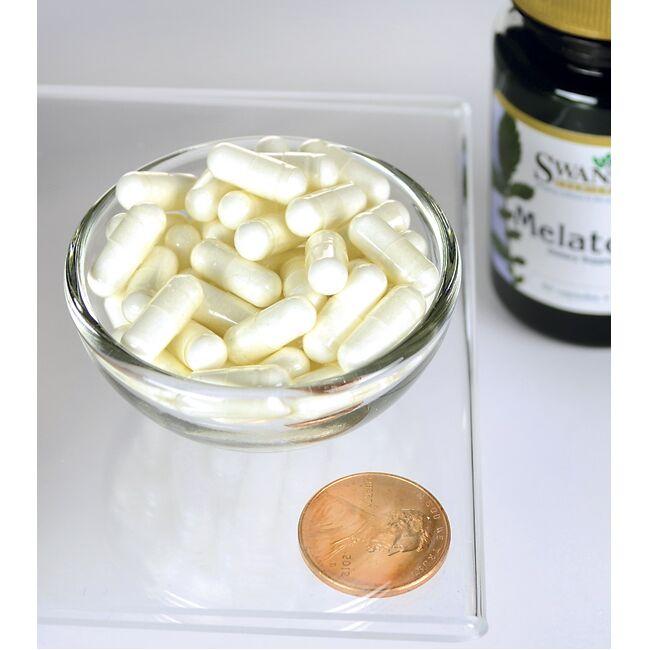 Un bol de Swanson Melatonin 3 mg 60 capsules à côté d'un penny.