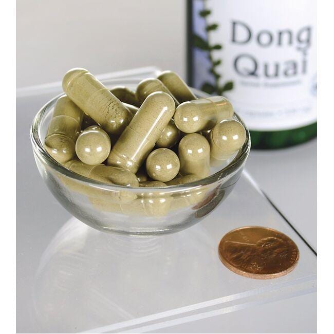 Swanson Dong Quai - 530 mg 100 gélules dans un bol à côté d'une bouteille.