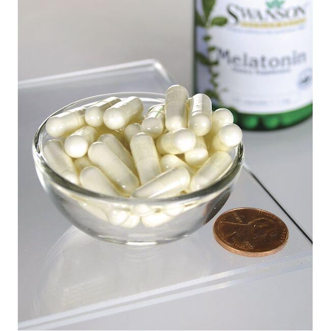 Swanson Mélatonine - 1 mg 120 gélules dans un bol à côté d'une bouteille de Swanson Melatonin.
