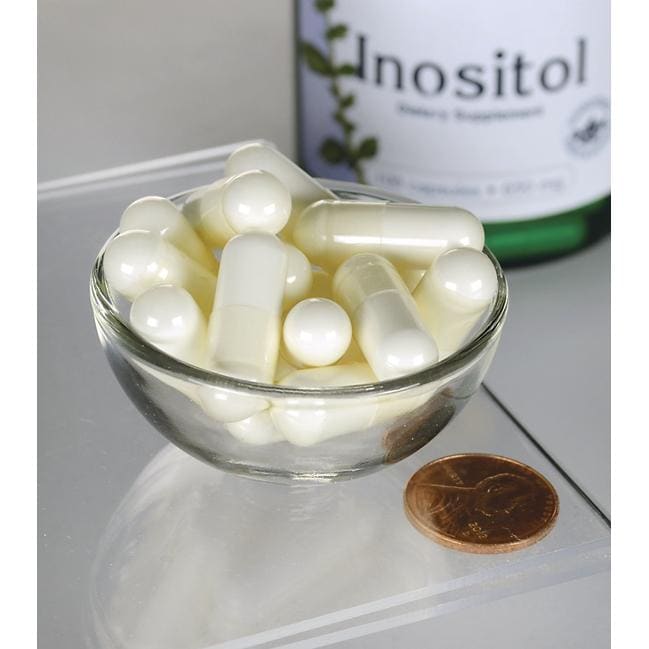 Swanson Inositol - 650 mg 100 gélules dans un bol à côté d'une bouteille d'Inositol Swanson .