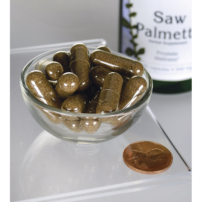 SwansonSaw Palmetto - 540 mg 100 gélules, un supplément populaire de soutien à la prostate, sont présentées dans un bol à côté d'un penny.