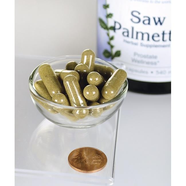 Swanson Saw Palmetto - 540 mg 250 gélules, connues pour leur rôle dans la promotion de la santé de la prostate et de l'écoulement des voies urinaires, sont présentées dans un bol à côté d'un penny.