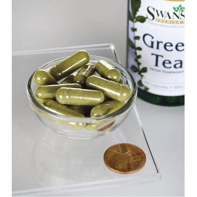 Une bouteille de thé vert Swanson - 500 mg 100 gélules avec un penny à côté.