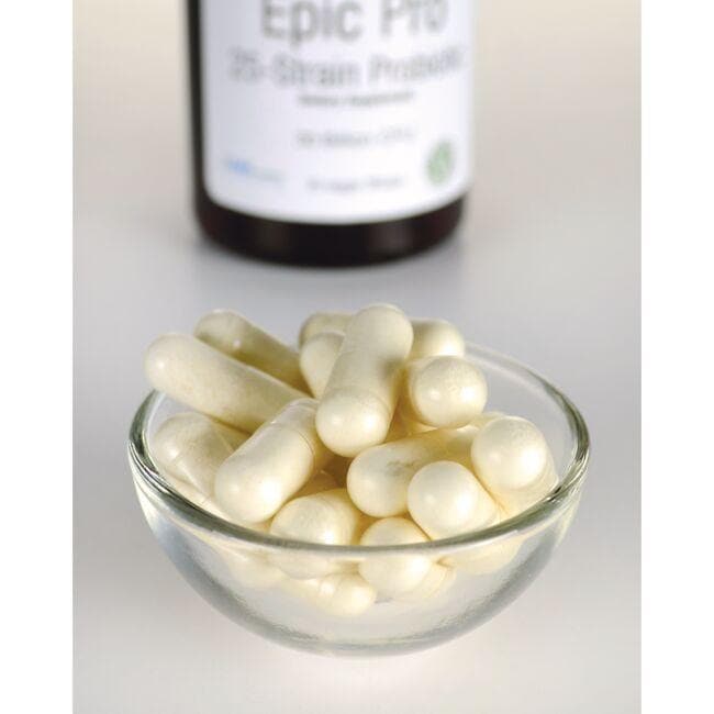 Un bol de pilules blanches à côté d'une bouteille de Swanson's Epic Pro 25-Strain Probiotic - 30 gélules végétales.