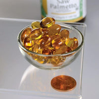 Vignette d'un bol de Swanson Saw Palmetto - 160 mg 120 softgel à côté d'un penny, promouvant la santé de la prostate.