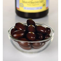 Thumbnail for A small glass bowl filled with brown capsule-shaped supplements, designed for cardiovascular health, with a partially visible Swanson Ubiquinol 100 mg 60 Softgels supplement bottle in the background.