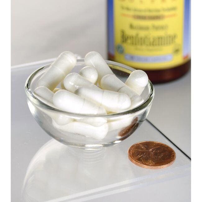A small glass bowl filled with white Swanson Vitamin B-1 Benfotiamine 300 mg 60 Veggie Capsules, placed next to a penny for size comparison, with a container of medication in the background.