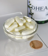 Vignette d'un flacon de Swanson DHEA - High Potency - 25 mg 120 gélules dans un bol à côté d'un penny.